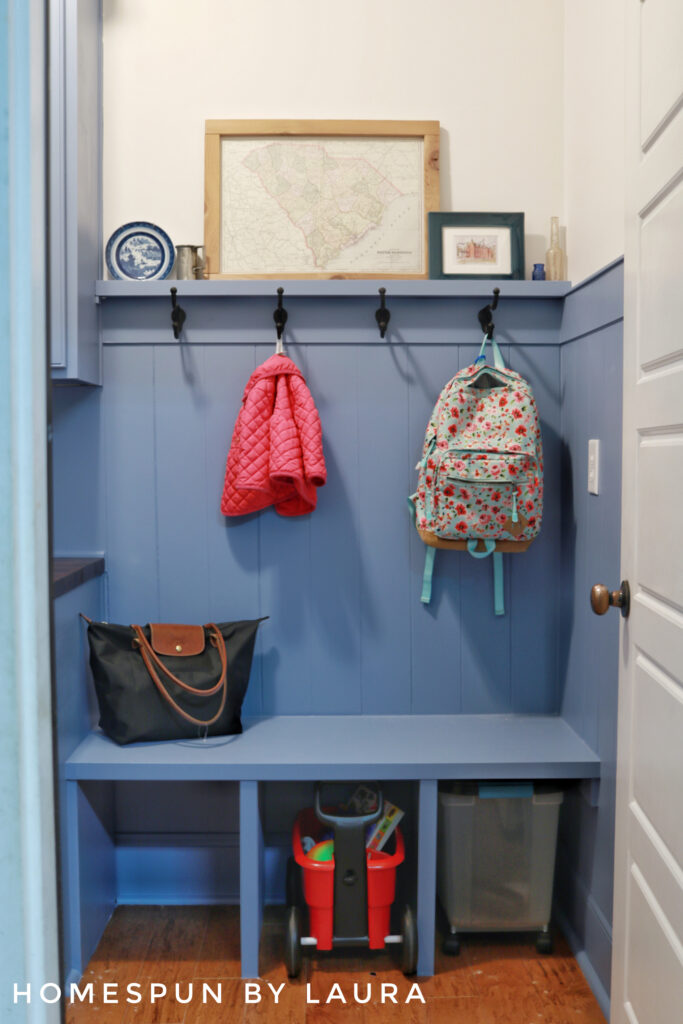 DIY Mud Room with vertical shiplap planks, hooks, and storage bench Reveal