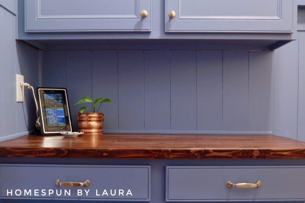 DIY Mud Room with vertical shiplap planks, hooks, 2x6 counters, and storage bench Reveal