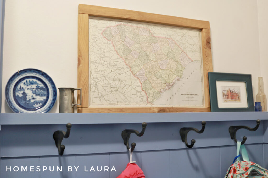 DIY Mud Room with vertical shiplap planks, hooks, 2x6 counters, and storage bench Reveal